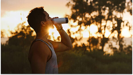men drinking energy drink at sunset