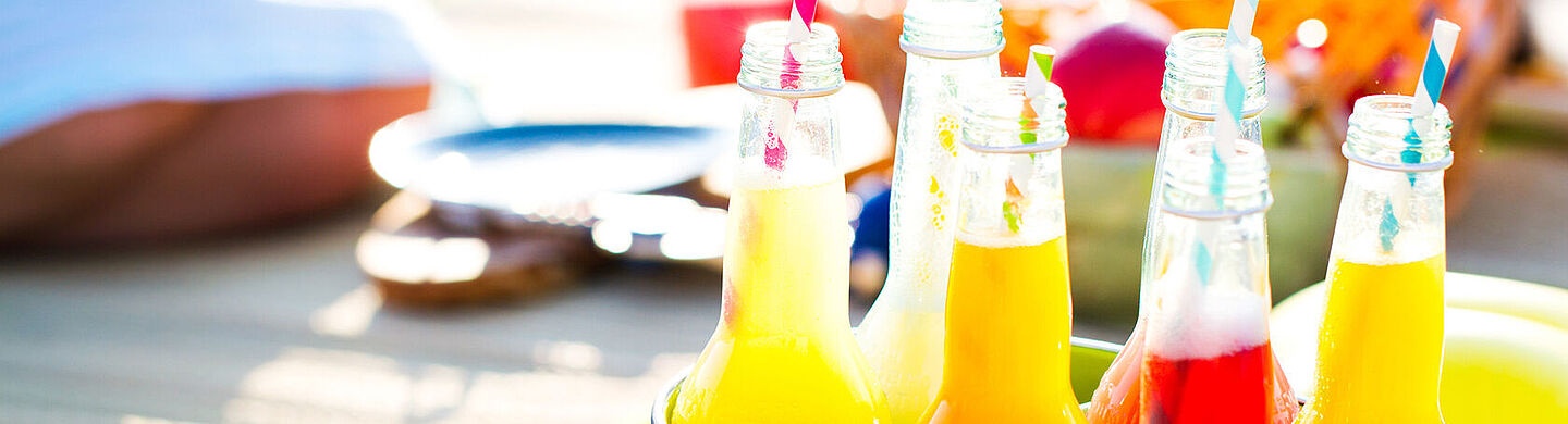 botellas con líquido amarillo, naranja y rojo