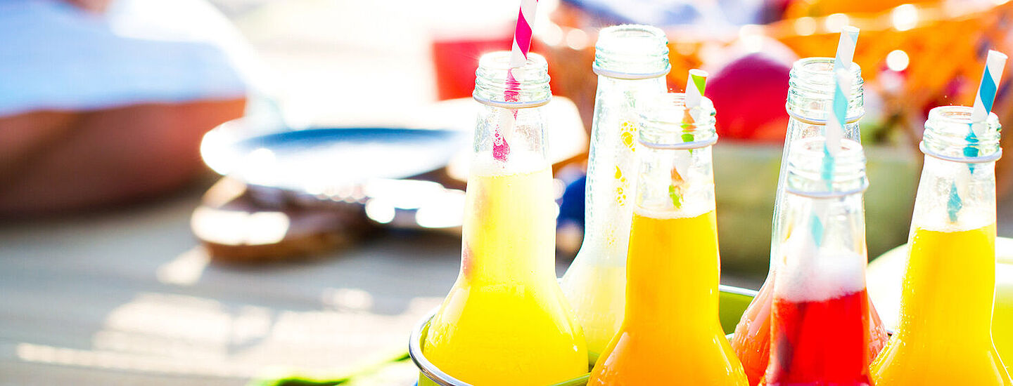 garrafas com líquido amarelo, laranja e vermelho