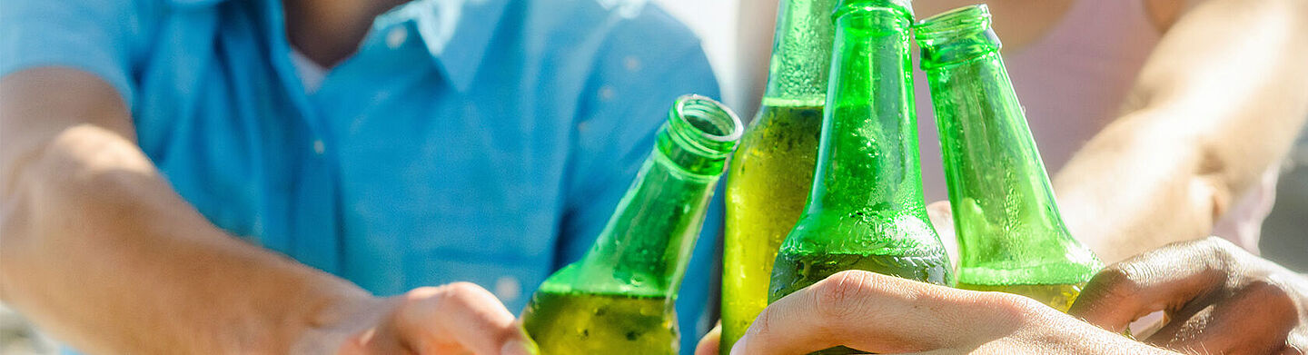 amigos brindando con cerveza en botellas verdes