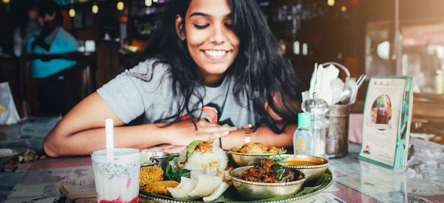 mulher comendo comida indiana