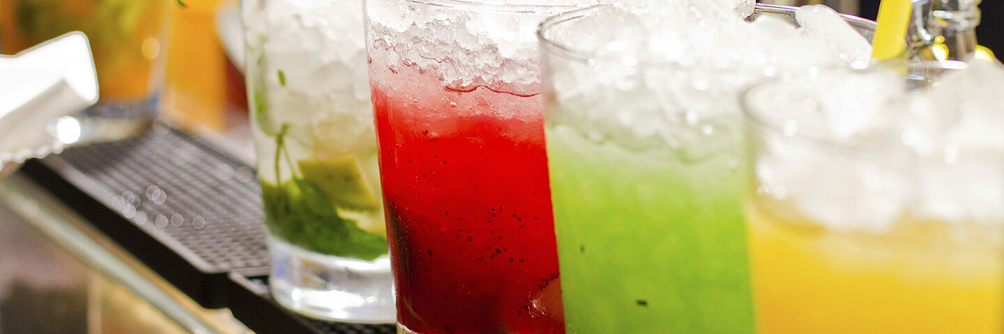 four colourful drinks with ice