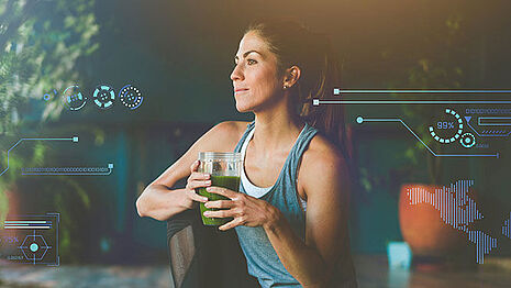 A woman is drinking green juice.