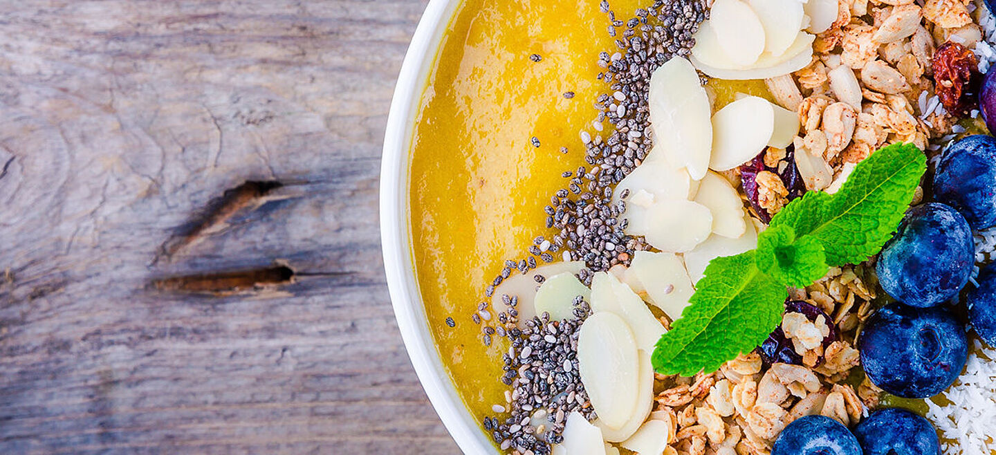 Smoothie-Schüssel mit Orangenflüssigkeit mit Blaubeeren