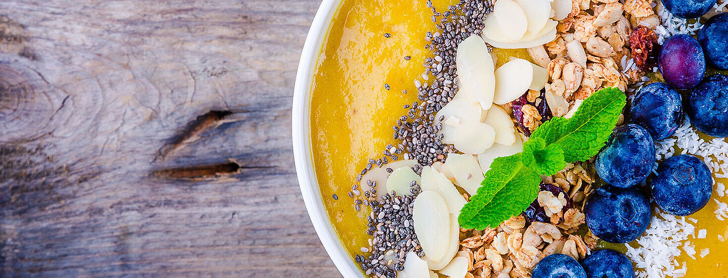 Smoothie-Schüssel mit Orangenflüssigkeit mit Blaubeeren