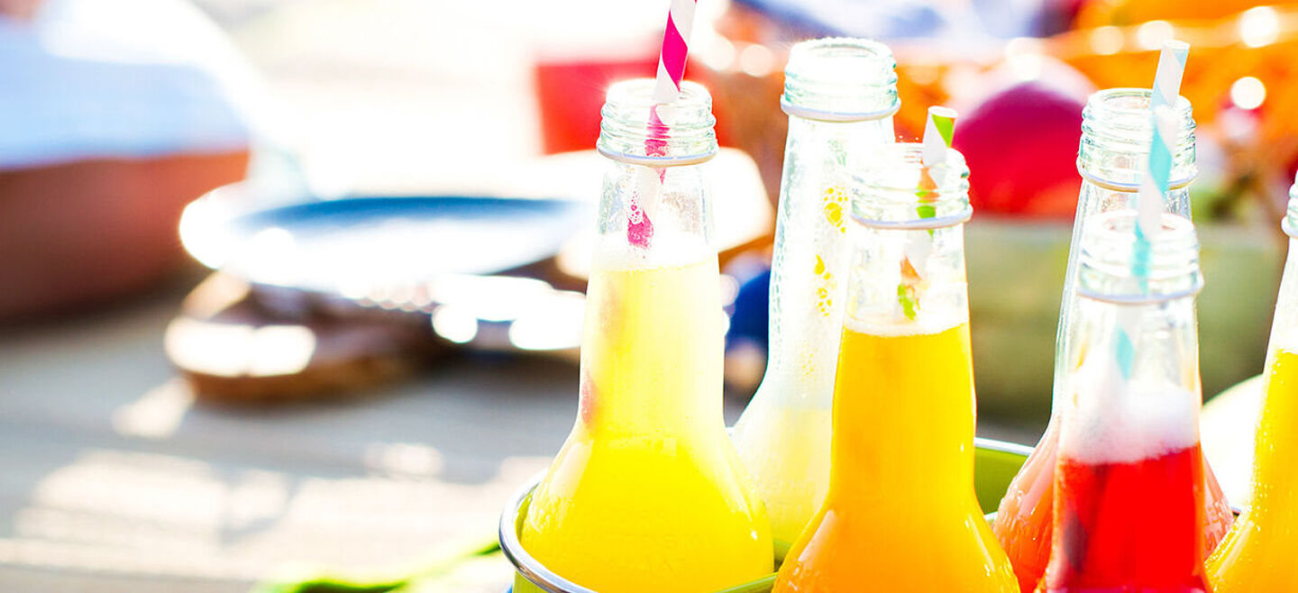 botellas con líquido amarillo, naranja y rojo