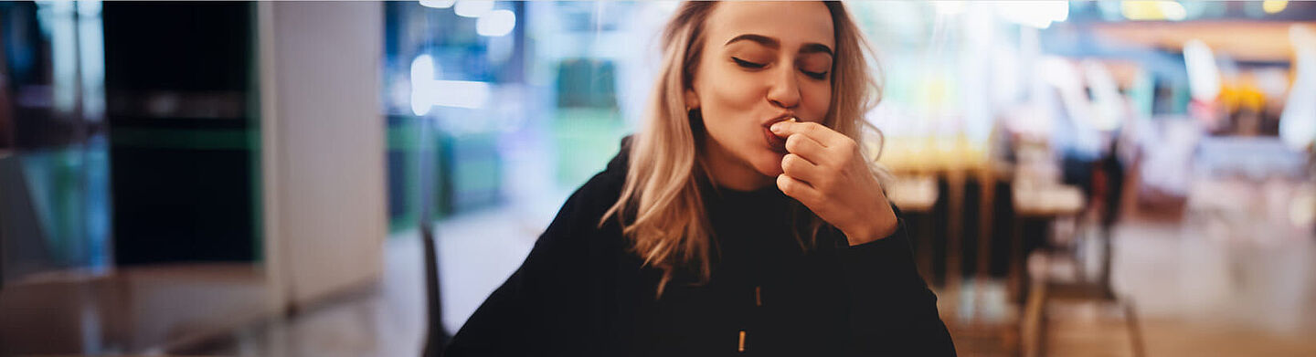 Woman sit in a cafe and eats a piece of cake