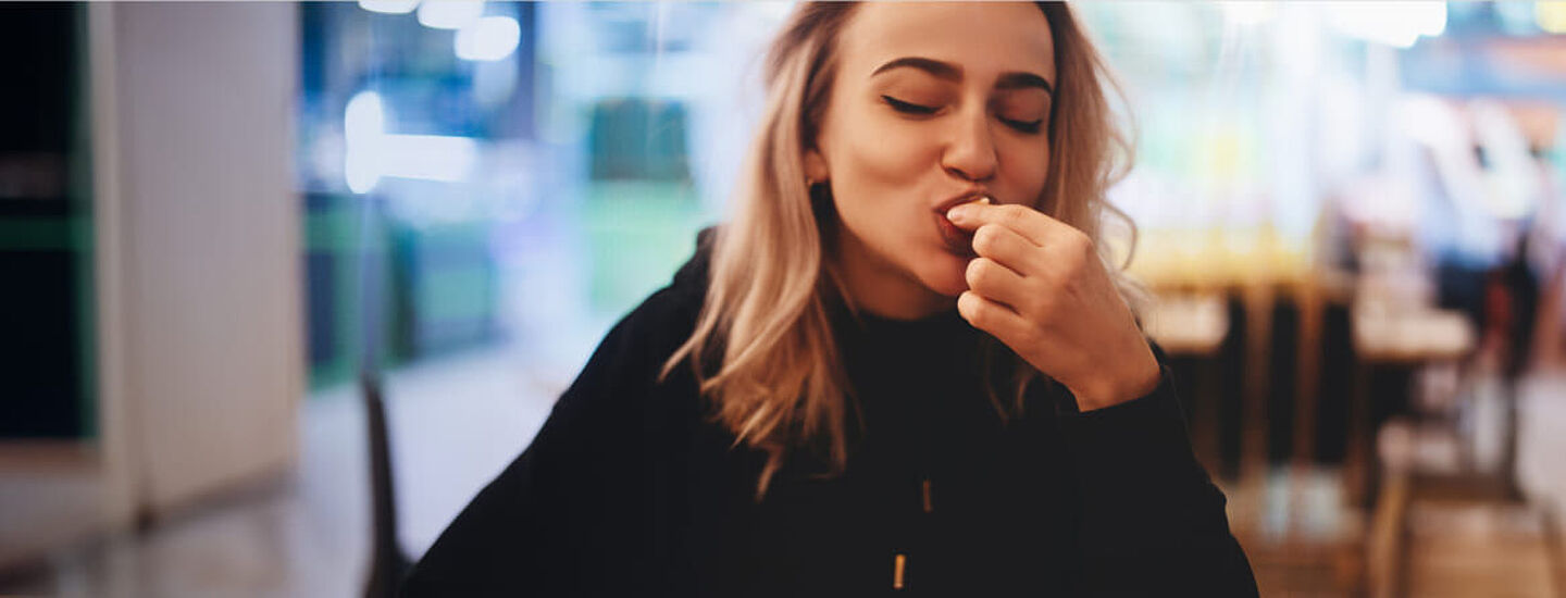 Mulher em um café comendo um pedaço de bolo