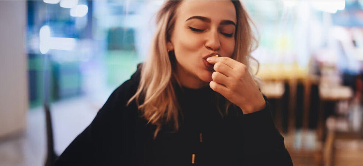 Woman sit in a cafe and eats a piece of cake