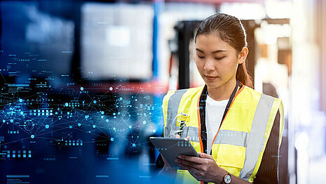 一名女子身穿道路安全反光背心，正在写字板上书写