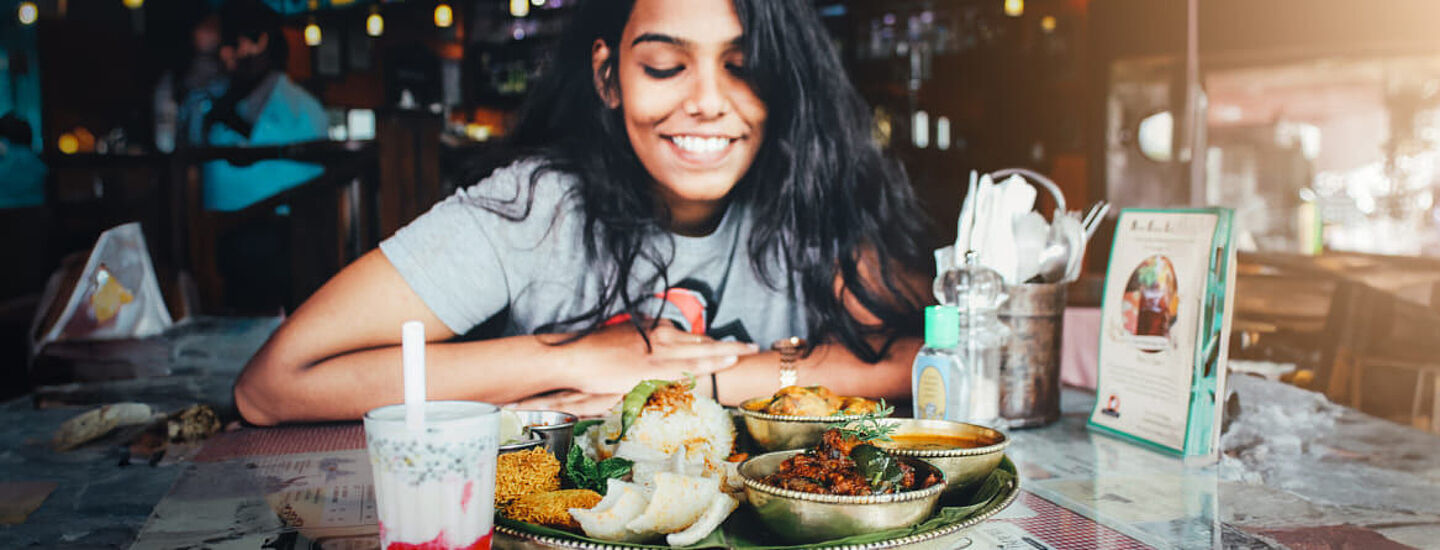 mulher comendo comida indiana