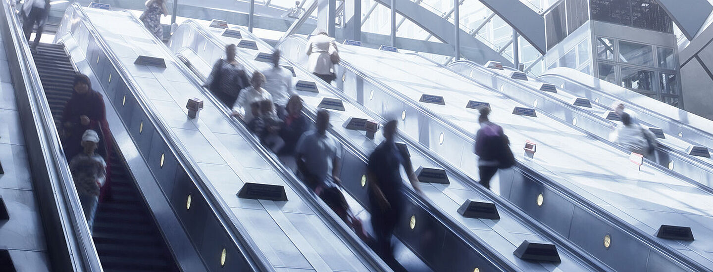 personas en escaleras mecanicas