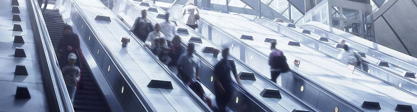 personas en escaleras mecanicas