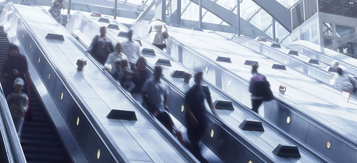 personas en escaleras mecanicas