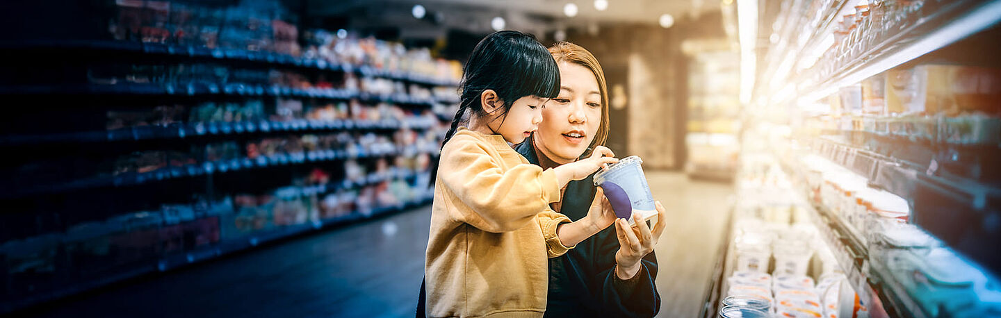Eine Mutter und ihre Tochter wählen Produkte im Lebensmittelgeschäft aus