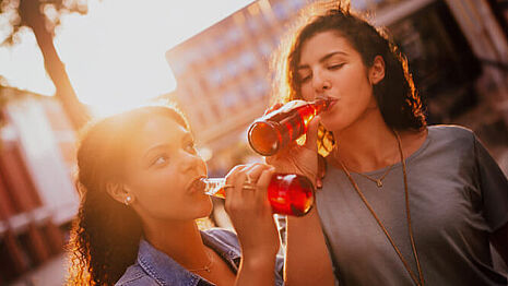 Two women drinking fruit splahes