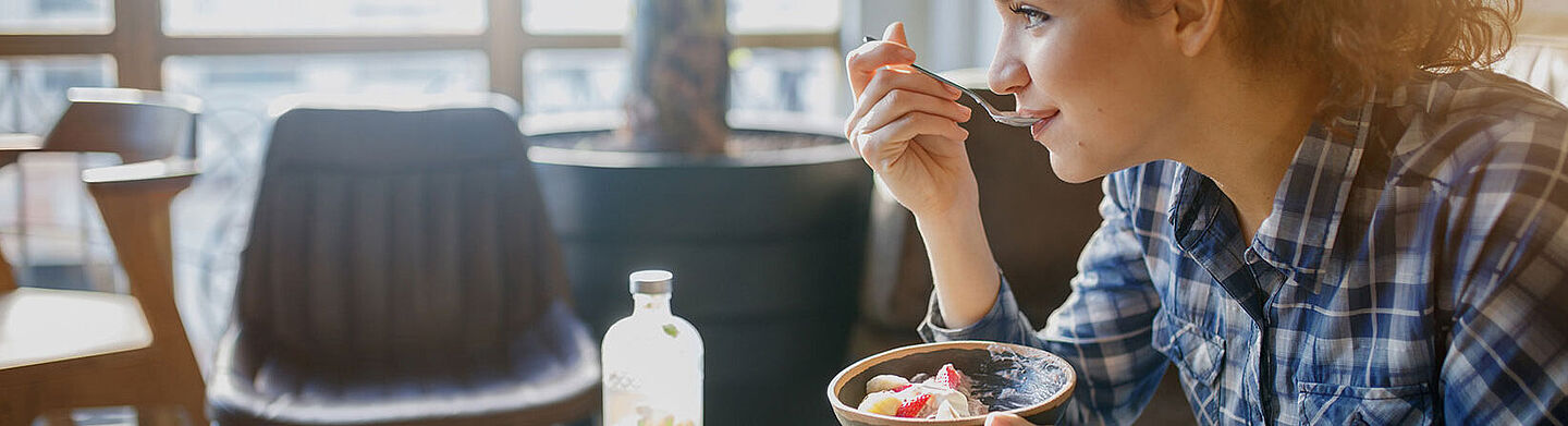 young woman eats a dessert with a spoon