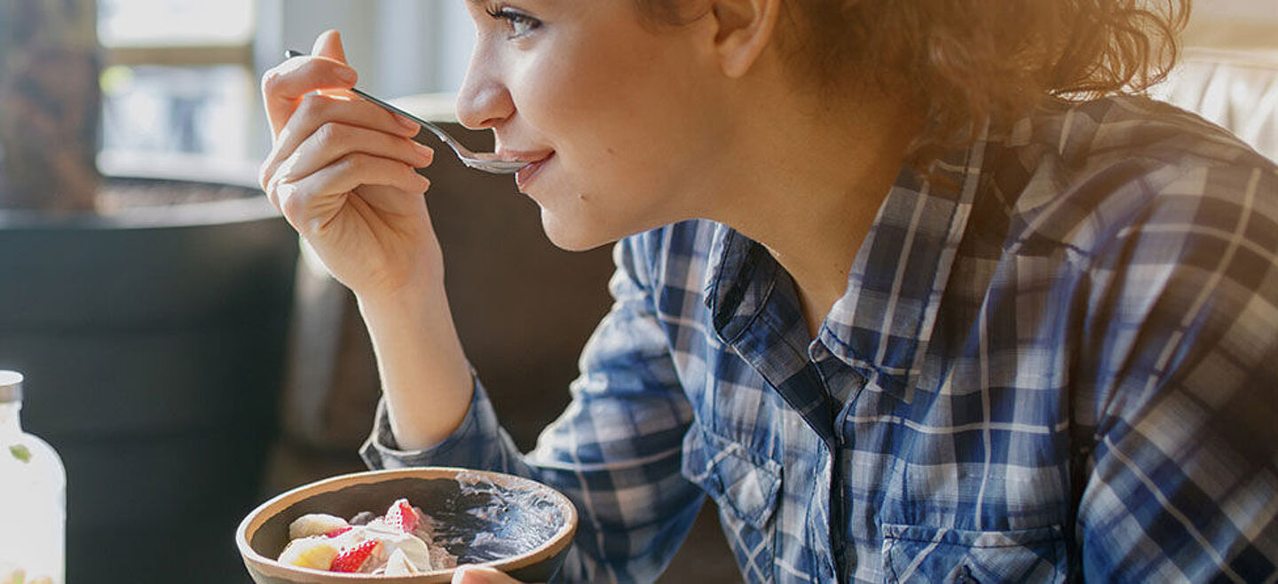 una joven come un postre con una cuchara