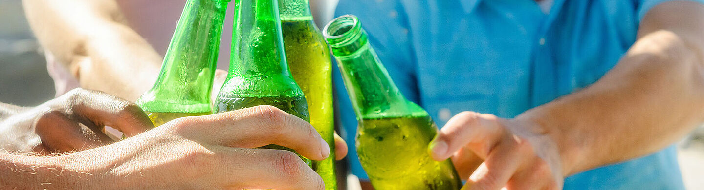 friends cheering with beer on green bottles