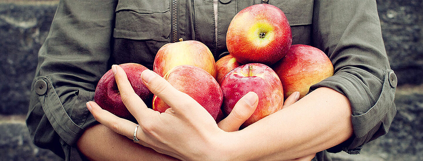 someone holding red apples