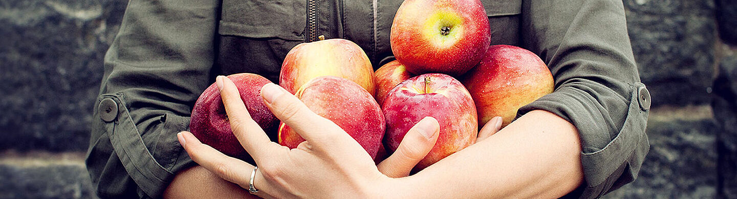 someone holding red apples