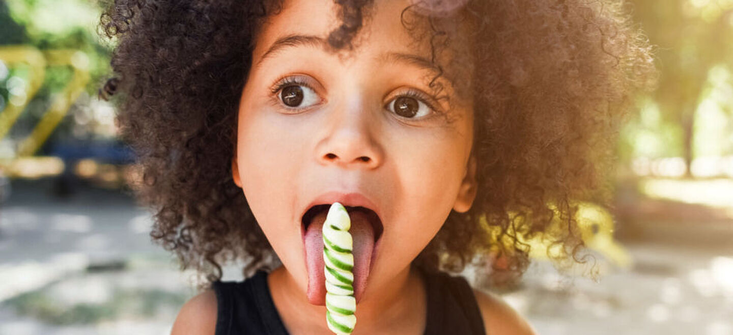 little kid eating a lolipop