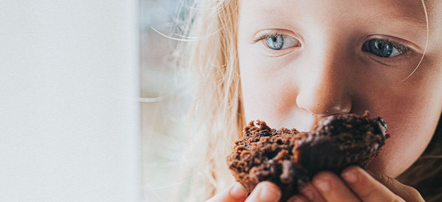 menina a comer bolo de chocolate