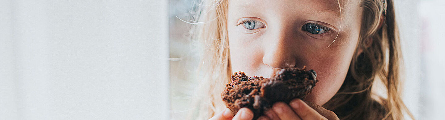 menina a comer bolo de chocolate