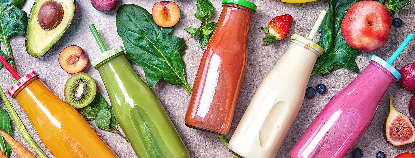 Botellas coloridas de frutas y verduras con jugo o batido