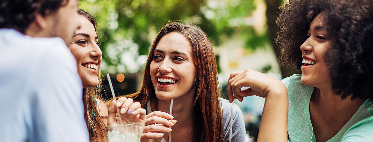 Freunde mit Naturhintergrund bei einem Drink