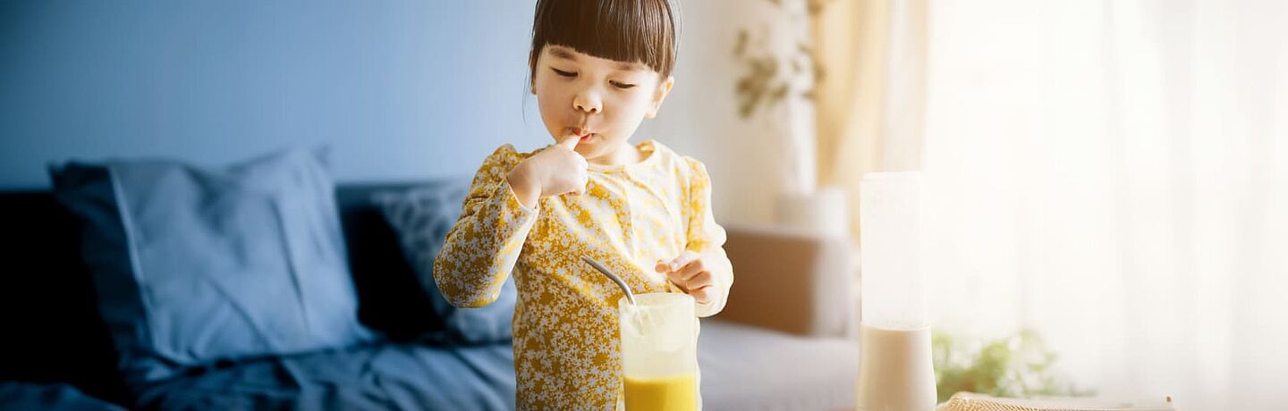 Mädchen isst Orangen-Smoothie