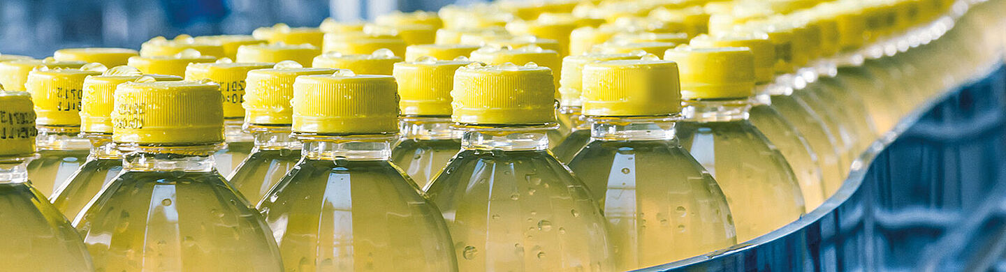 Verschiedene Flaschen mit gelber Flüssigkeit und gelbem Flaschenverschluss