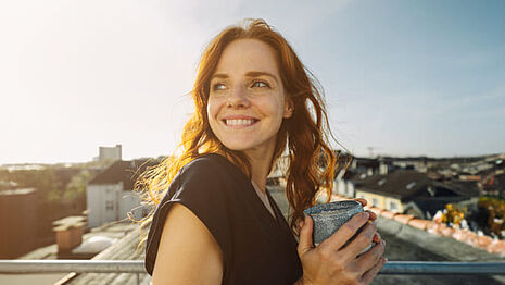 Eine lächelnde Frau mit einer Tasse Tee