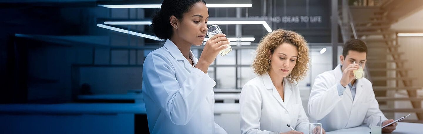 Menschen in Laborkitteln testen Lebensmittel