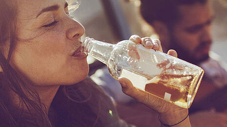 Frau trinkt an einer Flasche