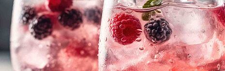 duas bebidas gaseficadas com frutos vermelhos