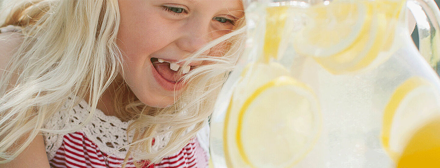 little girl with lemon water