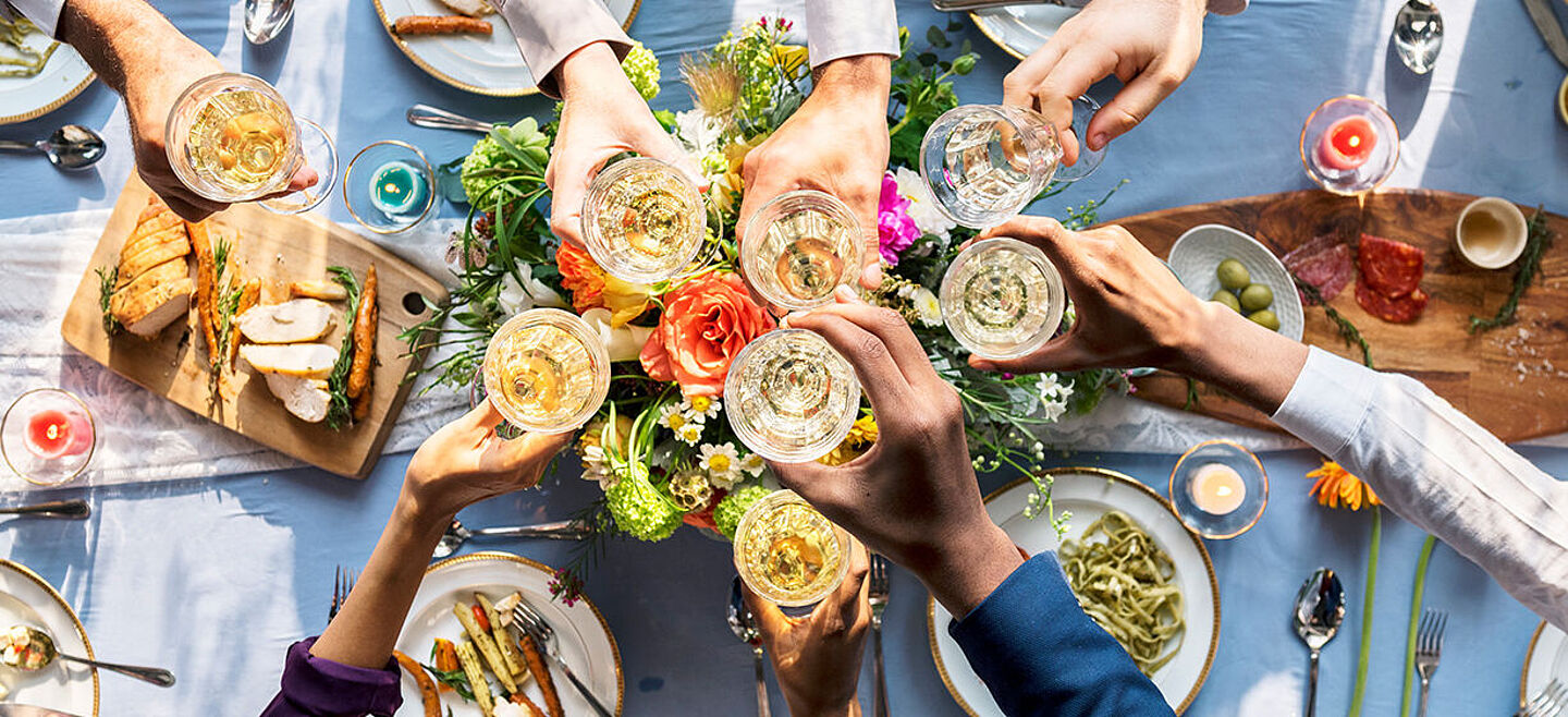 Tisch mit Essen und jubelnden Menschen