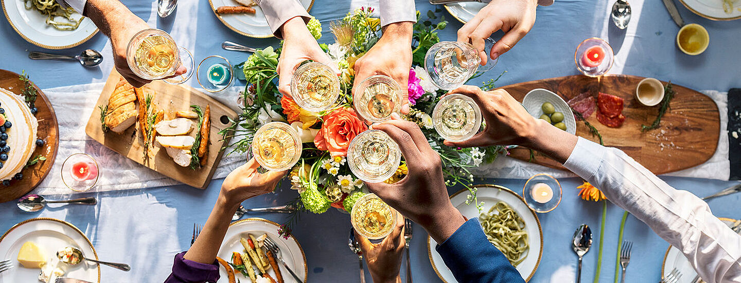 Tisch mit Essen und jubelnden Menschen