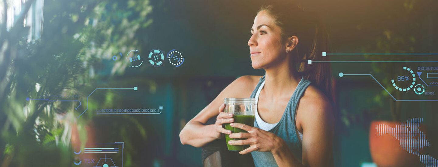 Woman in sportswear holding a green smoothie in her hand