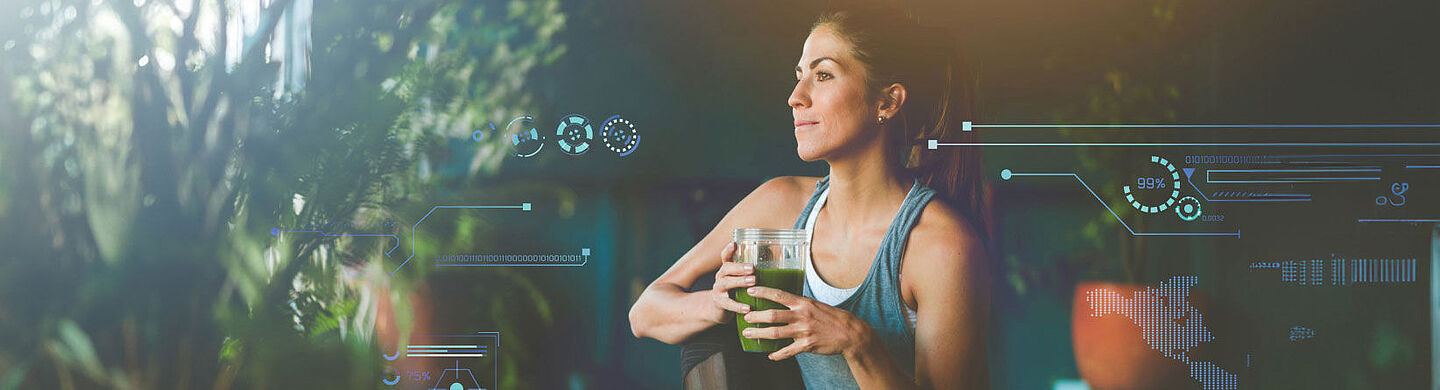 Woman in sportswear holding a green smoothie in her hand