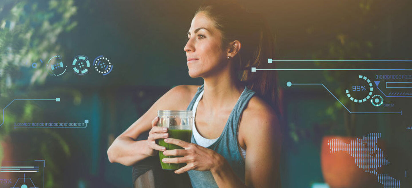 [Translate to Chinesisch:] Frau in Sportkleidung mit einem grünen Smoothie in der Hand