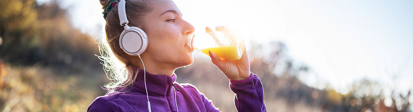 mujer bebendo liquido naranja