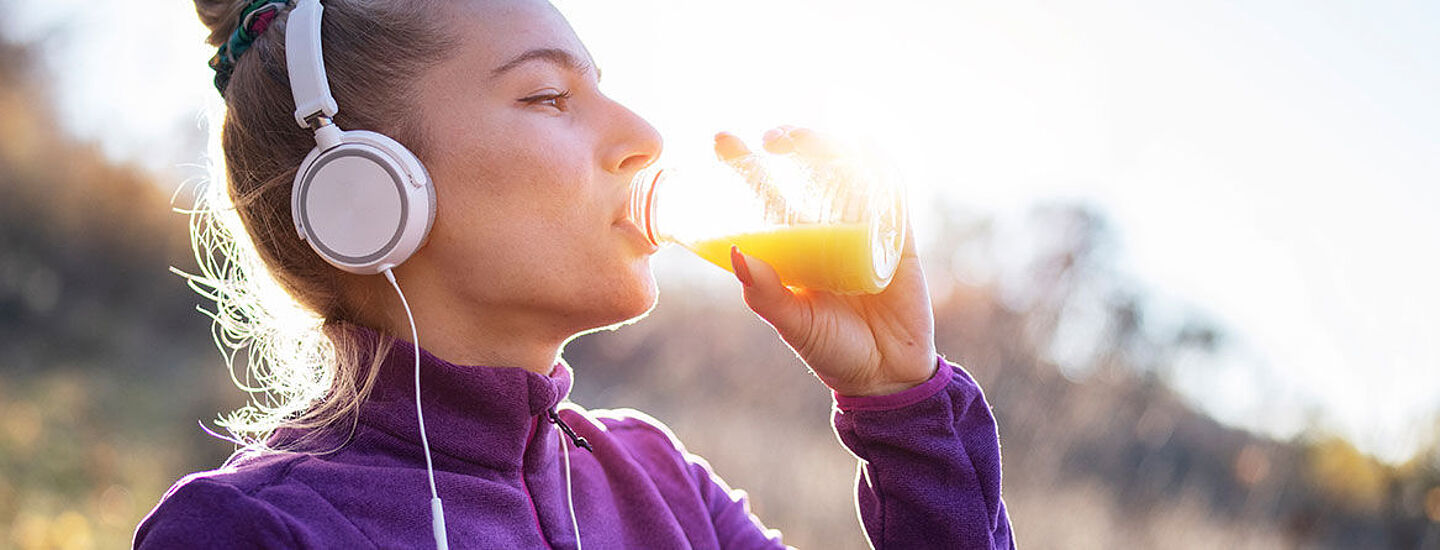 mujer bebendo liquido naranja