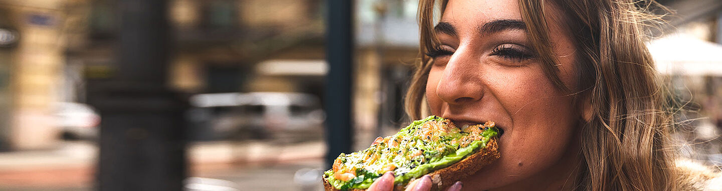 lady eating a bread with a cheese spread